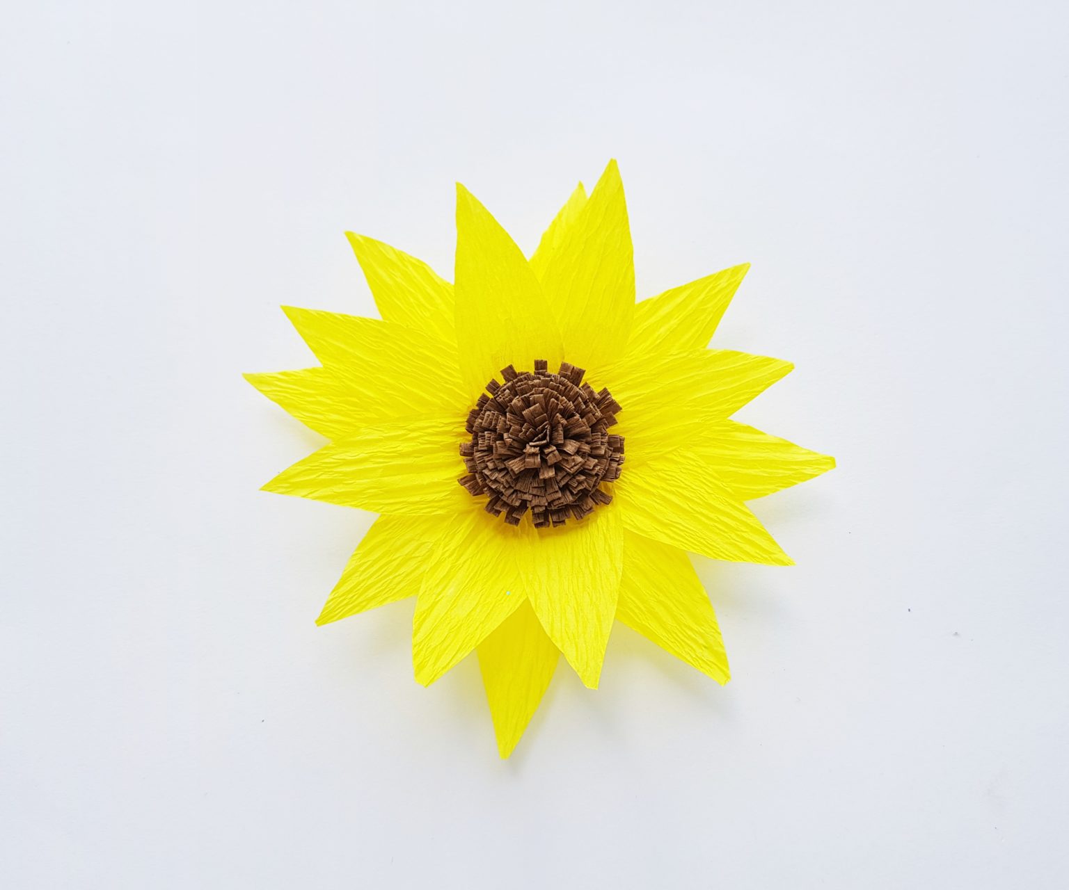 Attach the fringed roll piece on the center of the sunflower petals. 